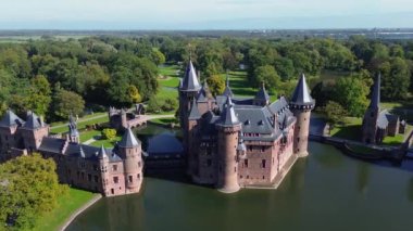 Hollanda 'nın en büyük şatosunun manzarası, De Haar. Şatonun, parkın ve kalenin etrafındaki su hendeğinin üzerinde güzel bir kuadkopter uçuşu. İngiliz tarzında güzel bir park..