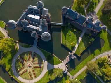 Hollanda 'nın en büyük şatosunun manzarası, De Haar. Şatonun, parkın ve kalenin etrafındaki su hendeğinin üzerinde güzel bir kuadkopter uçuşu. İngiliz tarzında güzel bir park..