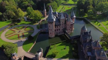 Hollanda 'nın en büyük şatosunun manzarası, De Haar. Şatonun, parkın ve kalenin etrafındaki su hendeğinin üzerinde güzel bir kuadkopter uçuşu. İngiliz tarzında güzel bir park..