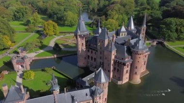 Hollanda 'nın en büyük şatosunun manzarası, De Haar. Şatonun, parkın ve kalenin etrafındaki su hendeğinin üzerinde güzel bir kuadkopter uçuşu. İngiliz tarzında güzel bir park..