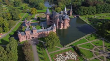 Hollanda 'nın en büyük şatosunun manzarası, De Haar. Şatonun, parkın ve kalenin etrafındaki su hendeğinin üzerinde güzel bir kuadkopter uçuşu. İngiliz tarzında güzel bir park..