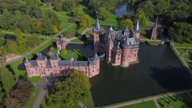 Hollanda 'nın en büyük şatosunun manzarası, De Haar. Şatonun, parkın ve kalenin etrafındaki su hendeğinin üzerinde güzel bir kuadkopter uçuşu. İngiliz tarzında güzel bir park..
