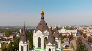 Ukrayna 'daki Zaporozhye şehrinin ve Ortodoks Katedrali' nin güzel hava manzarası. Hangi araçların yol aldığı sokaklar. Evlerin çatıları. Arka planda fabrika ve fabrika boruları.