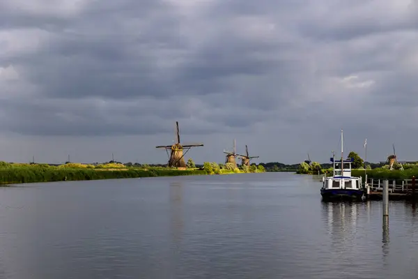 荷兰Kinderdijk村日落时分美丽的木制风车 风车在风中颠簸 美丽的荷兰运河充满了水 美丽的日落 — 图库照片