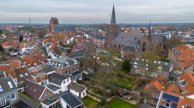 Beautiful view from above, from drone to orange, tiled roofs of houses. Top view of the Dutch city of Wijk bij Duurstede. The streets and roof of the church. Central Square of the city. clipart