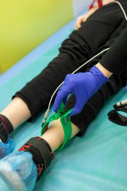 Kalp EKG cihazı. Hastanedeki kalbin elektrokardiyografisi. Hastanede bir çocuk elektrokardiyogram çekiliyor. Hastanede tedavi ve muayene.