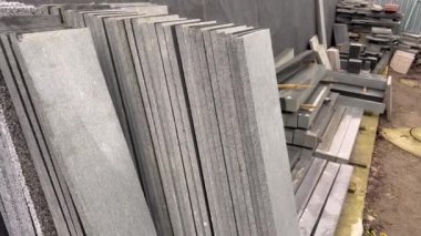 Granit levhalar sıra sıra dizilir. Mezar taşları için granit levhalar. Cenaze mezar taşları için atölye çalışması. Cenaze işleri. Mezar taşları.