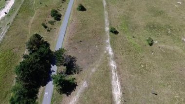 Sahildeki kijkduin ve deniz manzarası. Yeşil çimenler ve deniz kıyısındaki binalarla tarlaların üzerinden uçmak. Arka planda bir sürü ev var. Kuzey Denizi yakınlarındaki bir kuadrokopter tarlasından görüntüle