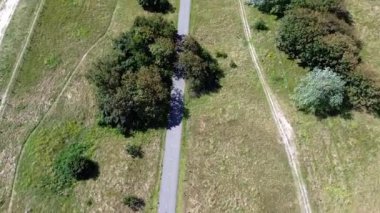 Sahildeki kijkduin ve deniz manzarası. Yeşil çimenler ve deniz kıyısındaki binalarla tarlaların üzerinden uçmak. Arka planda bir sürü ev var. Kuzey Denizi yakınlarındaki bir kuadrokopter tarlasından görüntüle