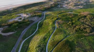 Yazın Katwijk aan Zee sahilinde güzel bir uçuş. İnsanlar deniz kenarında dinleniyor. Turistler için evler. Plaj şemsiyeleri, gezintiler, denizde yüzen insanlar. Bisiklet yolları. Kuzey Denizi.