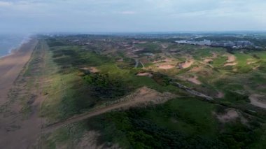 Yazın Katwijk aan Zee sahilinde güzel bir uçuş. İnsanlar deniz kenarında dinleniyor. Turistler için evler. Plaj şemsiyeleri, gezintiler, denizde yüzen insanlar. Hollanda 'da bir plaj. Kuzey Denizi.