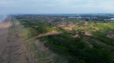 Yazın Katwijk aan Zee sahilinde güzel bir uçuş. İnsanlar deniz kenarında dinleniyor. Turistler için evler. Plaj şemsiyeleri, gezintiler, denizde yüzen insanlar. Hollanda 'da bir plaj. Kuzey Denizi.