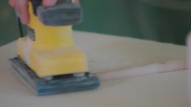 Tahta tahtalar ve kütükler özel bir makineyle zımparalanmış. Bir adamın eli kumlu tahta, ahşap. Zımparaladıktan sonra pürüzsüz tahta.