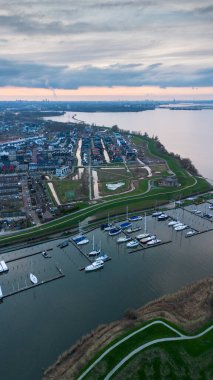 Birçok yat ve tekne körfeze demirlemiştir. Kuzey Denizi kıyılarında gün batımı. Hollanda 'nın çeşitli evleri, denizleri, kanalları insansız hava aracından çekildi. Üst görünüm.