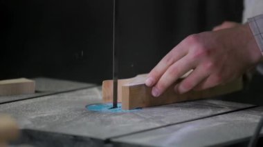 Bir adam atölyede ahşapla çalışır. Tahta kurusıkı ile çalışmak. Bir adam ahşap kurusıkı delikler açıyor. Bir marangoz çalışıyor. Metal atölyesi. Tahtayla çalışmak için makineler.