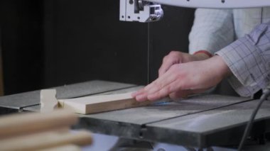 Bir adam atölyede ahşapla çalışır. Tahta kurusıkı ile çalışmak. Bir adam ahşap kurusıkı delikler açıyor. Bir marangoz çalışıyor. Metal atölyesi. Tahtayla çalışmak için makineler.