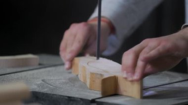 Bir adam atölyede ahşapla çalışır. Tahta kurusıkı ile çalışmak. Bir adam ahşap kurusıkı delikler açıyor. Bir marangoz çalışıyor. Metal atölyesi. Tahtayla çalışmak için makineler.