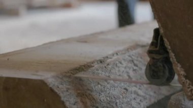 Bıçkıhanede, bir testere kahverengi ahşap keser. Ağaç kabuğu ve eski paslı testere. Yakın plan. Kereste fabrikasında çalış. Tahta ve odun parçalarından toz uçar.