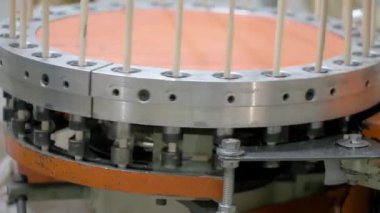 Bir makine ahşap kaplamaları işliyor, onları dairesel bir mekanizmada dikey olarak düzenliyor. Otomatik sistem üretim sırasında hassasiyeti ve tekdüzeliği sağlar..