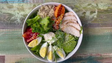 İçinde yulaf lapası, yumurta, doğranmış tavuk parçaları, marul, havuç, domates olan güzel bir kase. Lezzetli ve sağlıklı yiyecekler. Uygun beslenme.