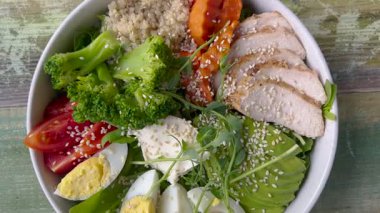 İçinde yulaf lapası, yumurta, doğranmış tavuk parçaları, marul, havuç, domates olan güzel bir kase. Lezzetli ve sağlıklı yiyecekler. Uygun beslenme.