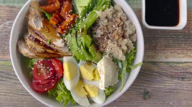 İçinde yulaf lapası, yumurta, doğranmış tavuk parçaları, marul, havuç, domates olan güzel bir kase. Lezzetli ve sağlıklı yiyecekler. Uygun beslenme.