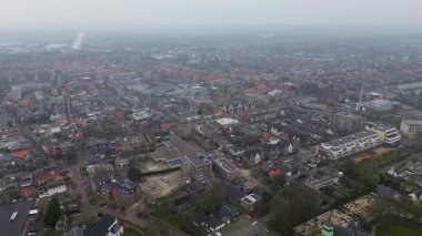 Yeşil kulesi olan tarihi bir kilisenin yer aldığı bir Avrupa kasabasının havadan görünüşü. Etrafında büyüleyici evler, ağaçlarla çevrili sokaklar ve huzurlu, iyi organize edilmiş bir mahalle düzeni var..