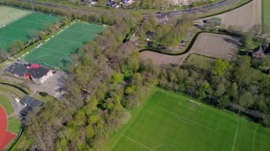 Merkezinde konut evleri, yeşil ağaçlar ve açık mavi bir bahar gününde açık mavi gökyüzü ile çevrili önemli bir kilisenin bulunduğu bir Hollanda kasabasının havadan görünüşü. Huzurlu ve büyüleyici bir atmosfer.