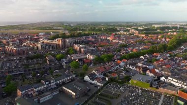 Dolambaçlı yolları olan geniş, düzgünce düzenlenmiş bir mezarlığın havadan görünüşü. Bir ormanın yakınındaki yemyeşil evlerle çevrili bir banliyö manzarası..