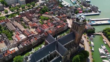 Deniz kenarındaki tarihi bir saat kulesinin büyüleyici hava manzarası. Etrafı büyüleyici Hollandalı evler, tekneler ve kanallarla çevrili. Sahne, eski Avrupa mimarisinin ve liman yaşamının güzelliğini yansıtıyor..