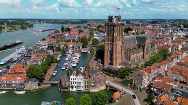Deniz kenarındaki tarihi bir saat kulesinin büyüleyici hava manzarası. Etrafı büyüleyici Hollandalı evler, tekneler ve kanallarla çevrili. Sahne, eski Avrupa mimarisinin ve liman yaşamının güzelliğini yansıtıyor..