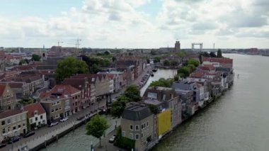 Kanalları, sıra sıra tarihi evleri, uzak bir katedrali ve parçalı bulutlu bir gökyüzünün altında geniş bir nehir üzerinde modern bir köprüsü olan büyüleyici bir Hollanda şehrinin havadan görünüşü..