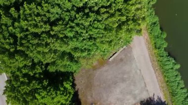 Dar bir barajın ya da dar bir geçidin havadan görünüşü her iki taraftaki geniş su kütleleri tarafından çevrelenmiş, dağınık bulutlarla dolu canlı mavi bir gökyüzünün altında ufka doğru yol alıyor..