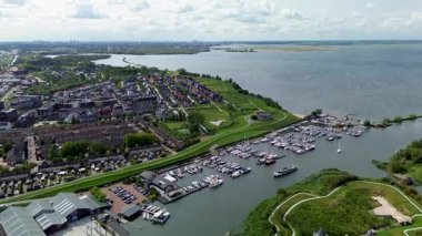 Hollanda 'daki Muiderslot Kalesi' nin göz kamaştırıcı hava manzarası, kanallarla çevrili, tekne dolu bir marina ve ufka doğru uzanan büyüleyici bir kasaba manzarası..