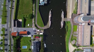 Kanalları, asansör köprüsü, kargo gemileri, modern binalar, güneş panelleri, yollar ve kentsel yaşamı su ve doğa ile harmanlayan yeşil alanlar..