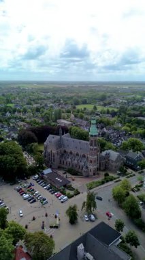 Tarihi bir kilisesi ve ufka uzanan yeşil alanları olan Avrupa 'nın çarpıcı bir hava manzarası. Mimarlık, yollar ve doğa karışımı huzurlu ve resimsel bir manzara yaratır..