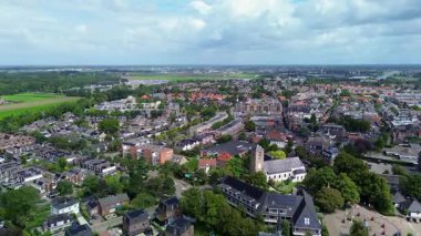 Kırmızı çatıları, yeşil ağaçları ve tarlalarıyla çevrili tarihi binaları olan büyüleyici bir Avrupa kasabasının havadan görünüşü doğa ve mimarinin barışçıl bir karışımını sergiliyor..