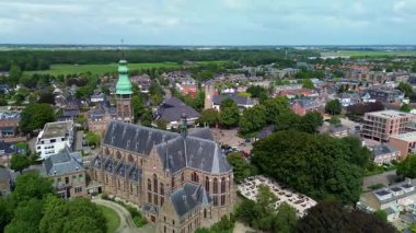 Tarihi bir kilisesi ve ufka uzanan yeşil alanları olan Avrupa 'nın çarpıcı bir hava manzarası. Mimarlık, yollar ve doğa karışımı huzurlu ve resimsel bir manzara yaratır..