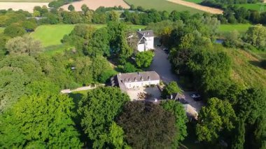 Yeşillik, tarlalar ve ağaçlarla çevrili U şeklinde bir avlusu olan büyüleyici tarihi bir malikane. Mimariyle doğal güzelliği harmanlıyor..