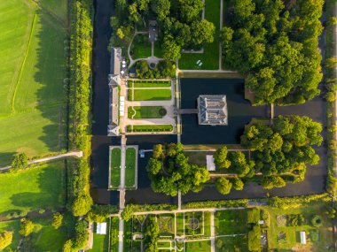 Simetrik bahçeli, köprülü ve dikdörtgen binalı havadan manzaralı bir arazi.