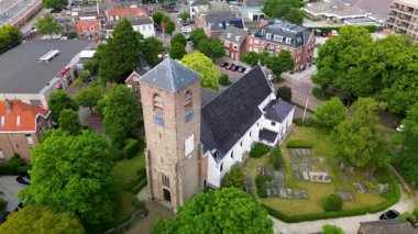 Evler, ağaçlar ve dar sokaklar ile çevrili merkezi taştan bir kilise ve uzun çan kulesiyle tarihi cazibeyi barışçıl bir kırsal alan ile harmanlayan tuhaf bir kasabanın havadan görünüşü..