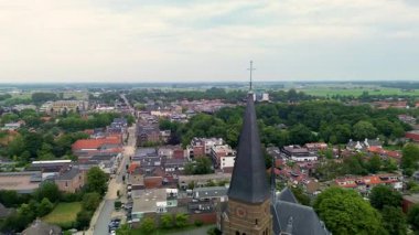 Merkezi yolu, tuğla kilise kulesi, evler, ağaçlar ve kırsal planlama, mimari ve doğal çevreyi harmanlayan uzak alanların havadan görünüşü..