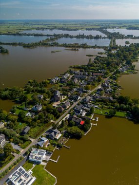 Merkezi bir kilise ve çan kulesiyle çevrili küçük bir kasabanın havadan görünüşü. Evler, ağaçlık sokaklar ve adalarla çevrili göller, tarihi cazibe ve doğal güzellikleri harmanlıyor..