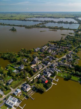 Merkezi bir kilise ve çan kulesiyle çevrili küçük bir kasabanın havadan görünüşü. Evler, ağaçlık sokaklar ve adalarla çevrili göller, tarihi cazibe ve doğal güzellikleri harmanlıyor..