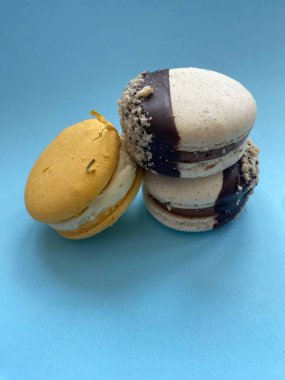 Mavi arka planda üç tatlı makaron. 