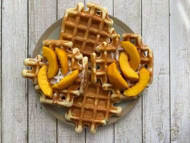 Şeftalili waffle, ahşap arka planda.