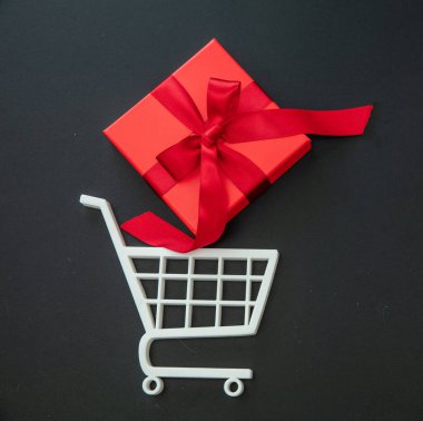 Alışveriş arabasındaki kırmızı hediye kutusu gibi. Kara Cuma indirimi, Noel hediyeleri. E ticaret, çevrimiçi satış konsepti