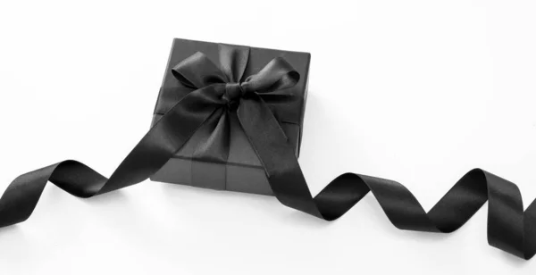 ブラックフライデーセールとクリスマスはコンセプトを提示します 白い背景に黒いリボンが描かれたギフトボックス — ストック写真
