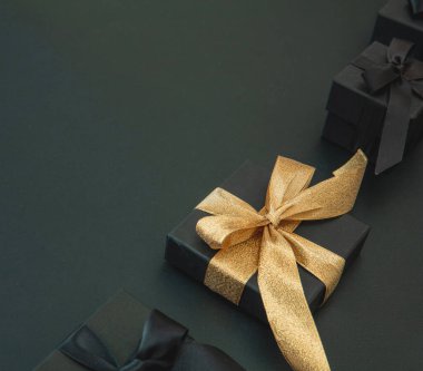 Kara Cuma indirimi ve Noel hediyeleri. İyi satın alma, pazarlık konsepti. Altın kurdeleli hediye kutuları 1, manzarayı kapatın.. 