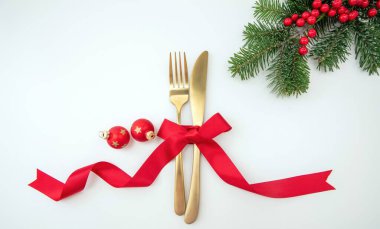 Noel bayramı yemeği. Yeni yıl sofrası. Altın çatal bıçak takımı, Xmas dekorasyonu ve kırmızı kurdele üst görünümü.